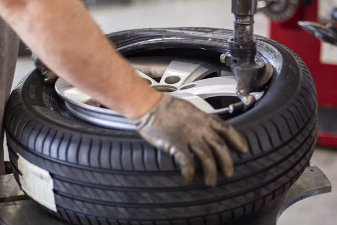 Mechaniker montiert einen Reifen auf der Reifenmontiermaschine